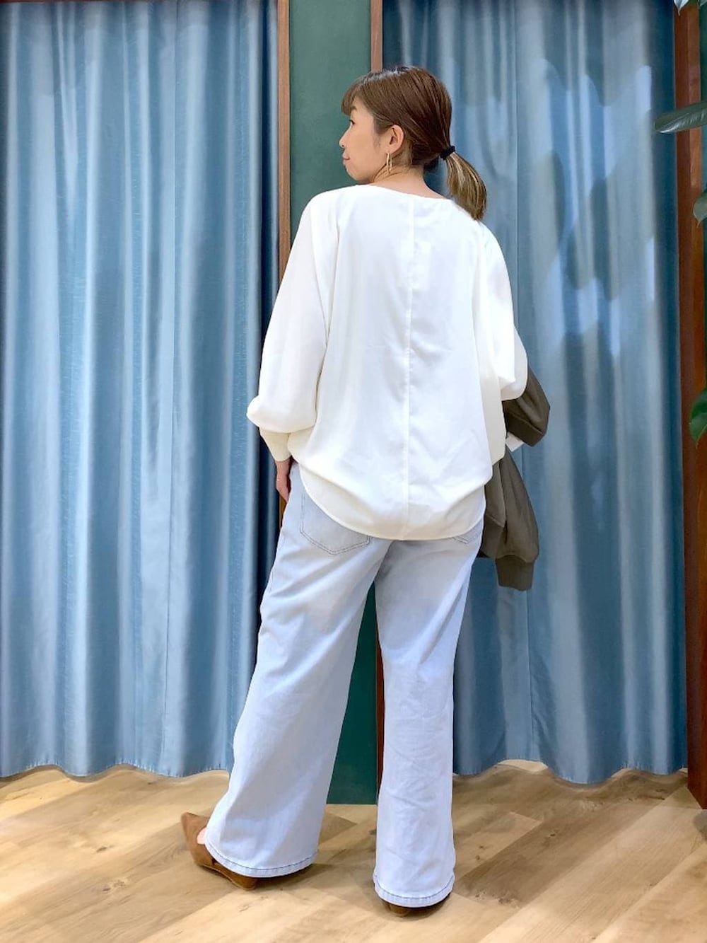 ブルー系のデニムパンツ、ホワイト系のTシャツ/カットソー、グリーン系のMA-1を着用したレディースの冬コーディネートの5枚目の写真