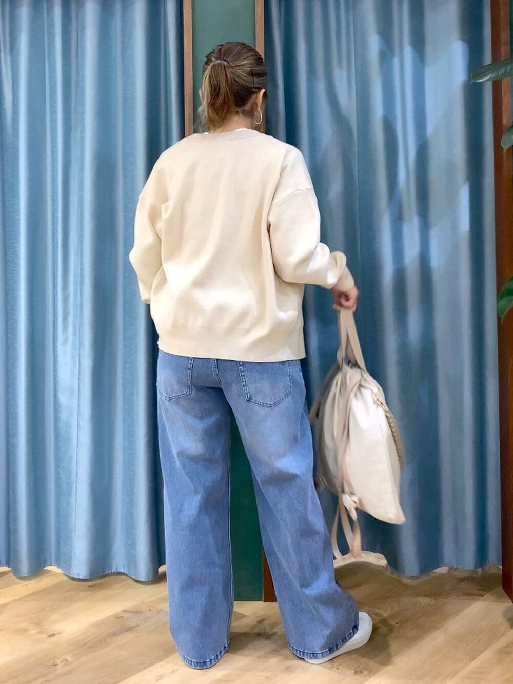 ホワイト系のカーディガン/ボレロ、ブルー系のデニムパンツ、ホワイト系のTシャツ/カットソーを着用したレディースの冬コーディネートの6枚目の写真