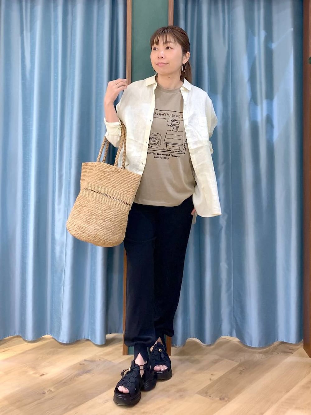 イエロー系のシャツ/ブラウス、ベージュ系のTシャツ/カットソー、ブラック系のサンダルを着用したレディースの春コーディネートの2枚目の写真