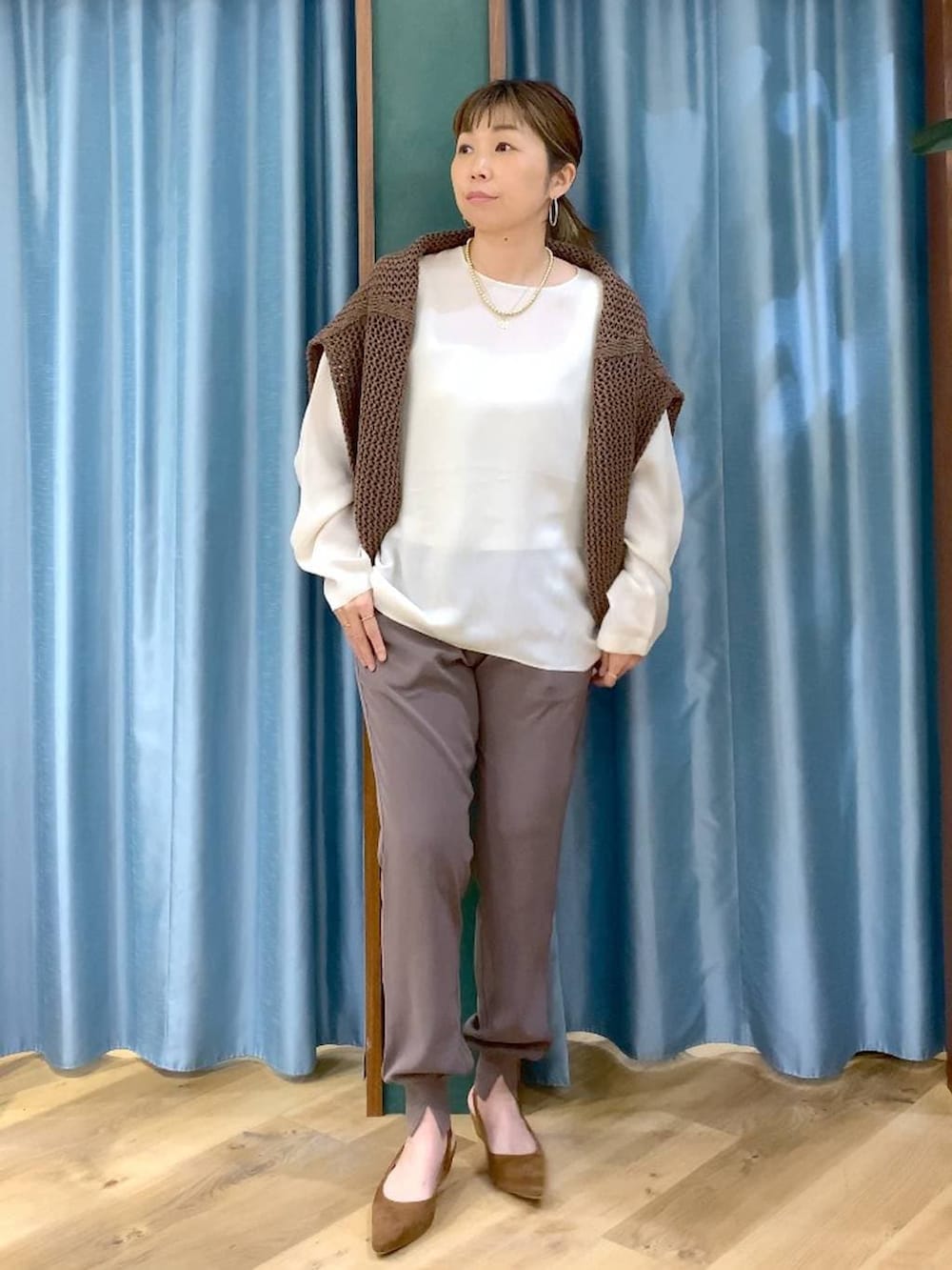 ブラウン系のニット/セーター、グリーン系のその他パンツ、ホワイト系のシャツ/ブラウスを着用したレディースの冬コーディネートの3枚目の写真