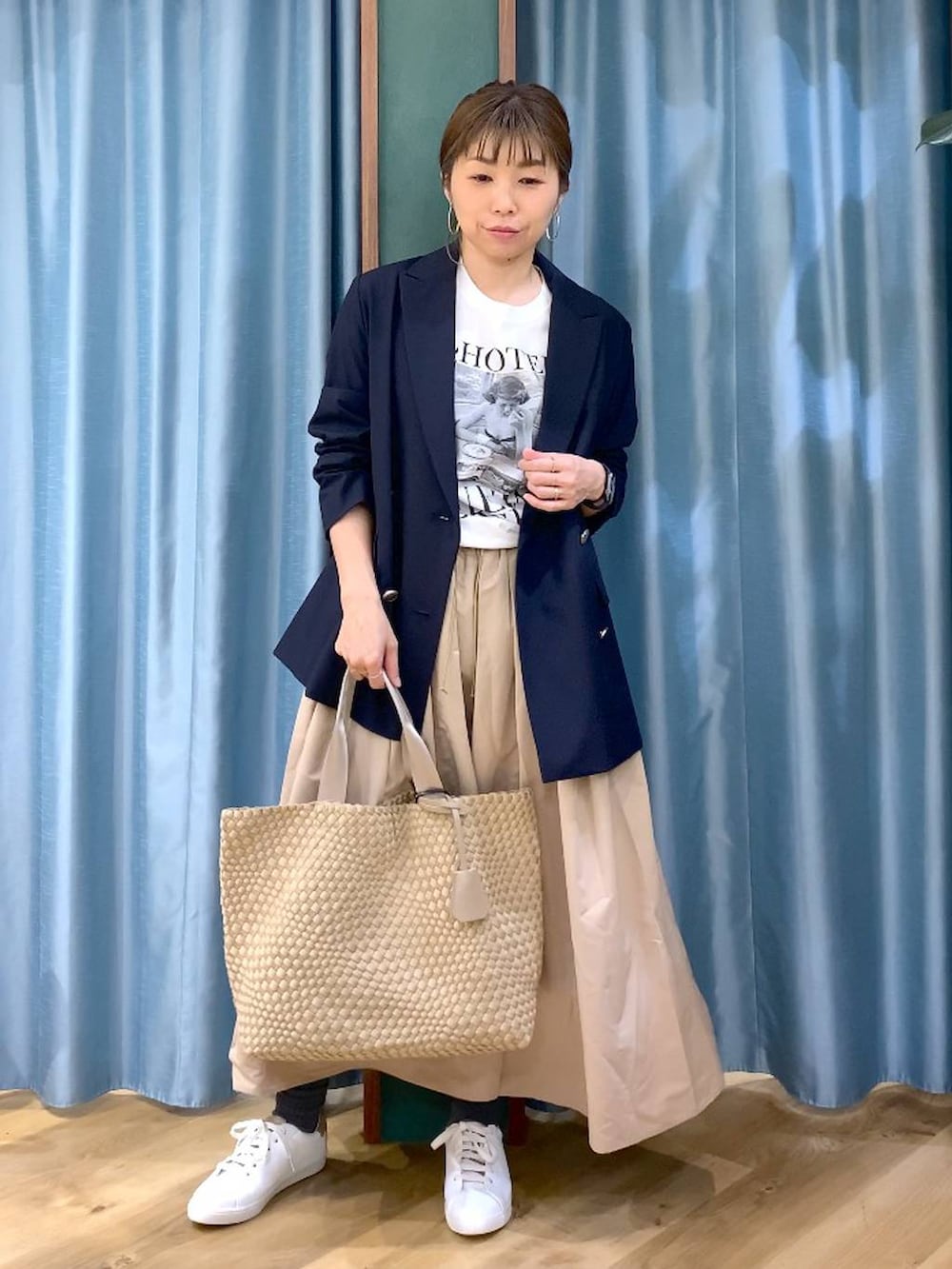 ベージュ系のスカート、ブルー系のテーラードジャケット、ベージュ系のトートバッグを着用したレディースの冬コーディネートの9枚目の写真