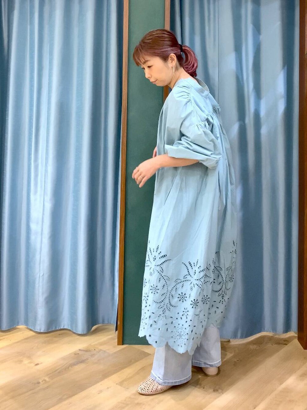 ブルー系のデニムパンツ、ベージュ系のスリッポン、グリーン系のワンピースを着用したレディースの春コーディネートの8枚目の写真