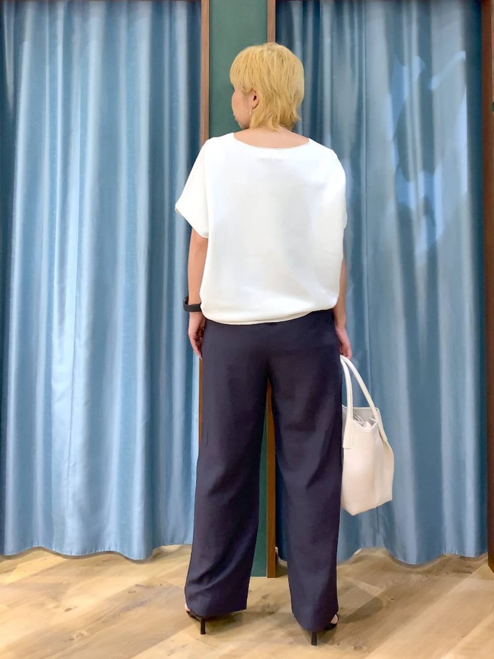 ホワイト系のトートバッグ、ホワイト系のニット/セーター、グレー系のその他パンツを着用したレディースの春コーディネートの5枚目の写真
