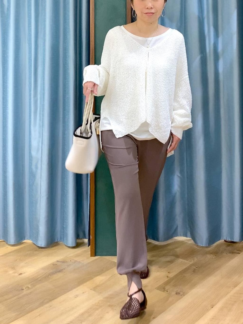 ホワイト系のTシャツ/カットソー、ホワイト系のカーディガン/ボレロ、ブラウン系のスリッポンを着用したレディースの春コーディネートの8枚目の写真