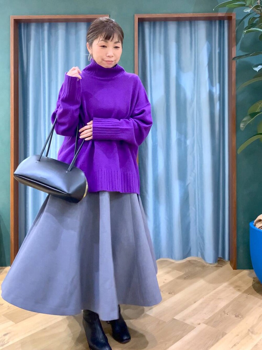 ブラック系のトートバッグ、グレー系のスカート、ブラック系のブーツを着用したレディースの秋コーディネートの8枚目の写真