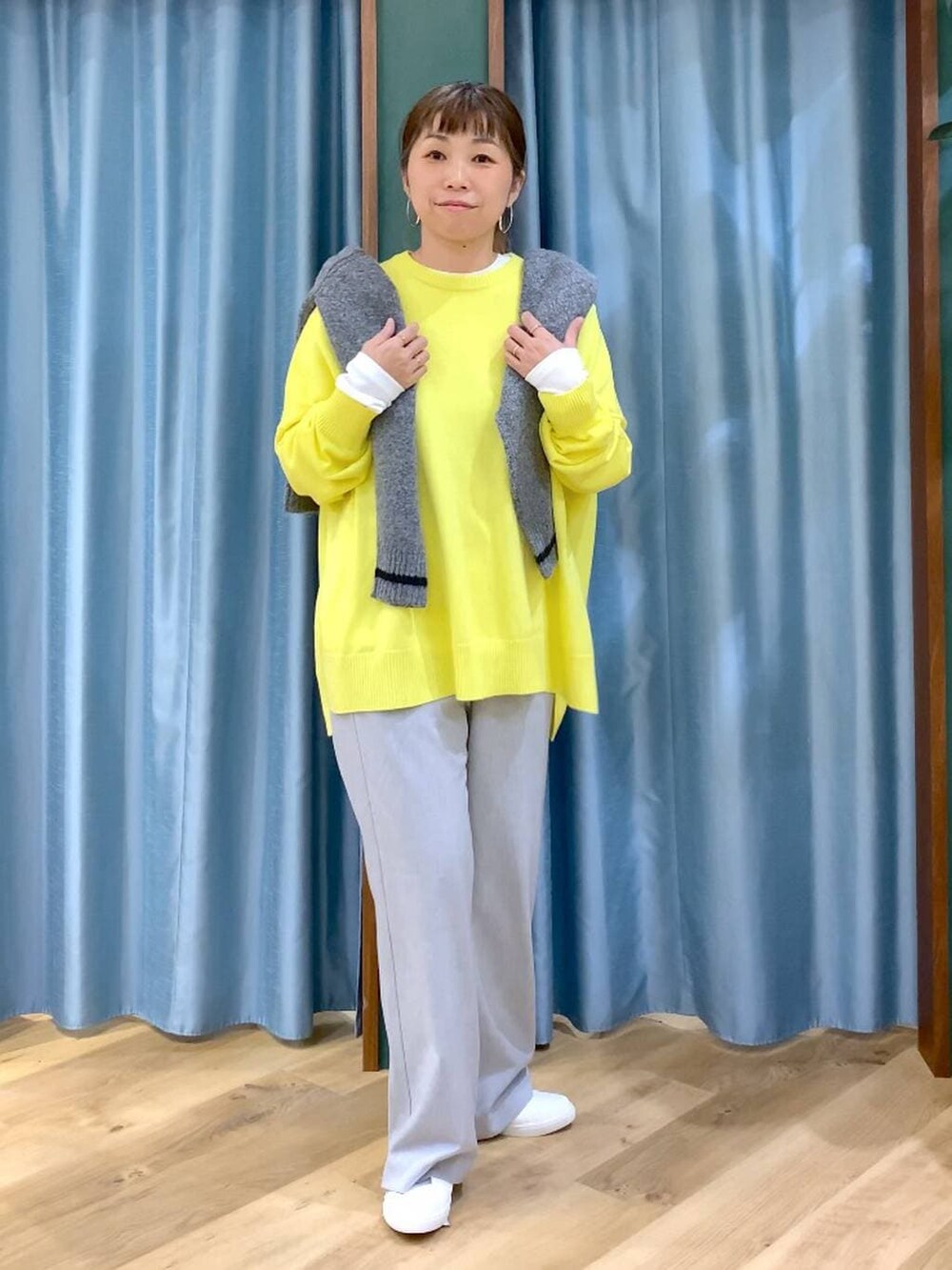 グレー系のカーディガン/ボレロ、ホワイト系のTシャツ/カットソー、イエロー系のニット/セーターを着用したレディースの秋コーディネートの5枚目の写真