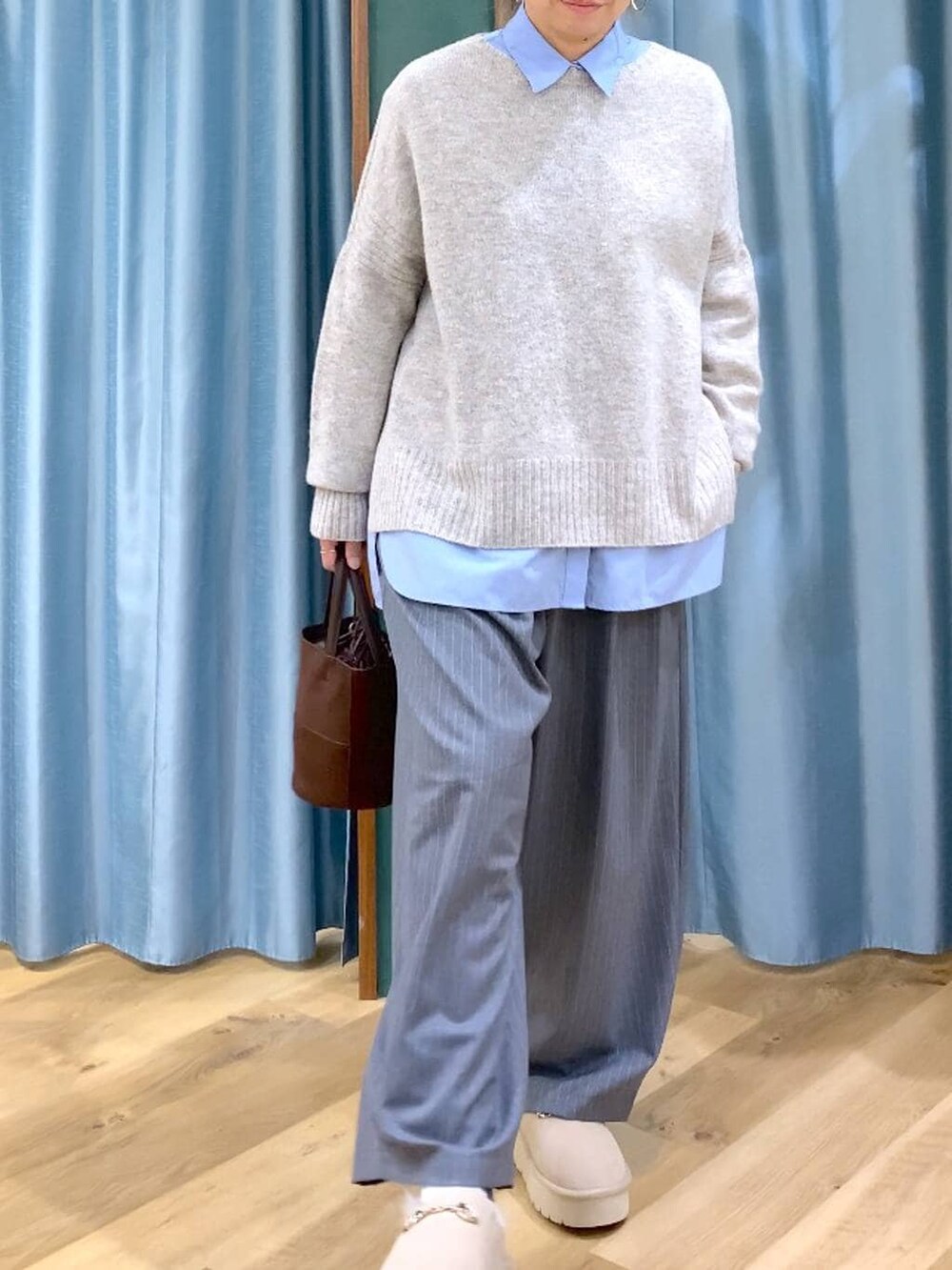 ブルー系のシャツ/ブラウス、ベージュ系のスリッポン、ベージュ系のニット/セーターを着用したレディースの冬コーディネートの10枚目の写真