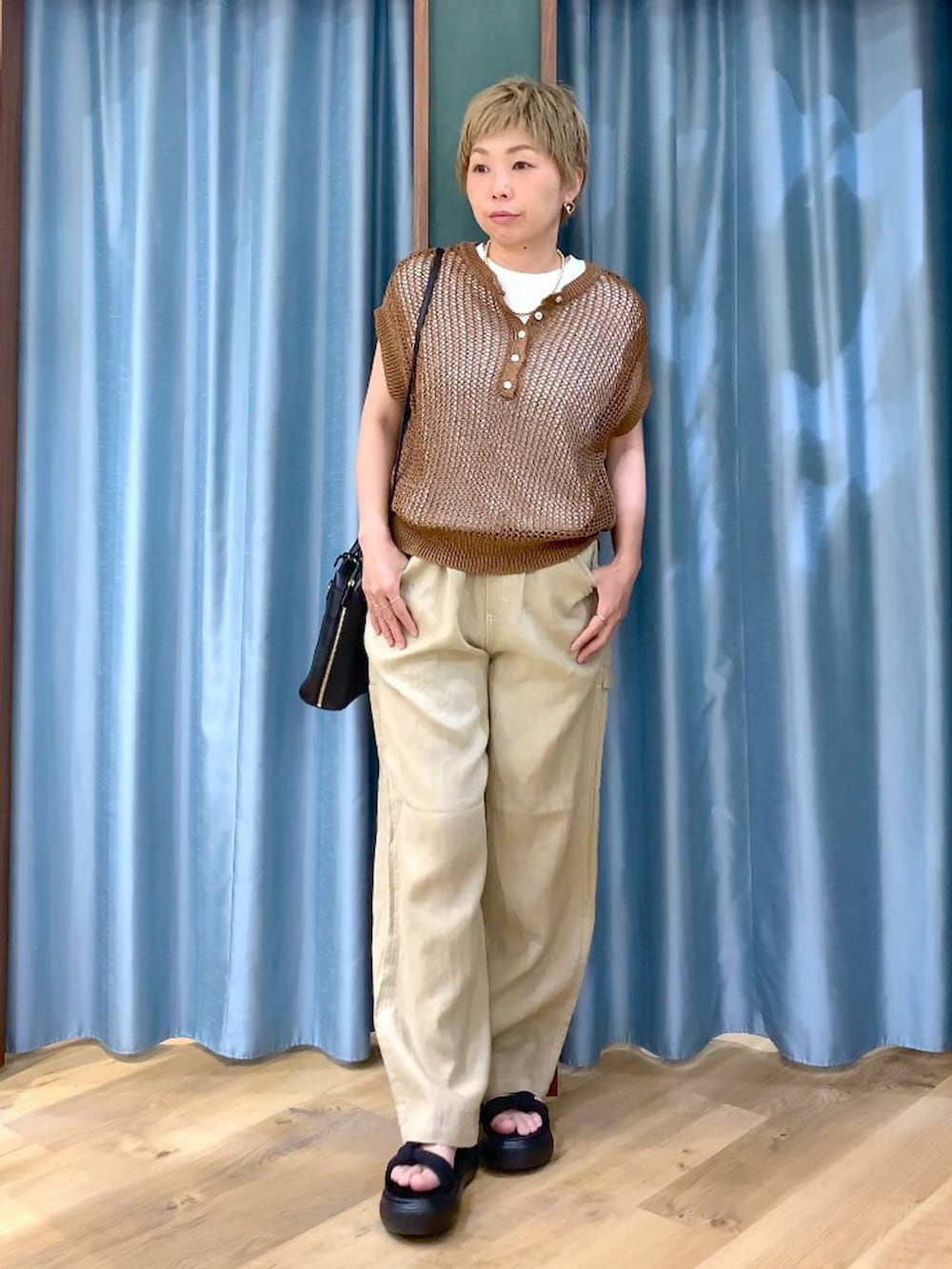 ホワイト系のTシャツ/カットソー、ベージュ系のその他パンツ、ブラック系のショルダーバッグを着用したレディースの夏コーディネートの2枚目の写真