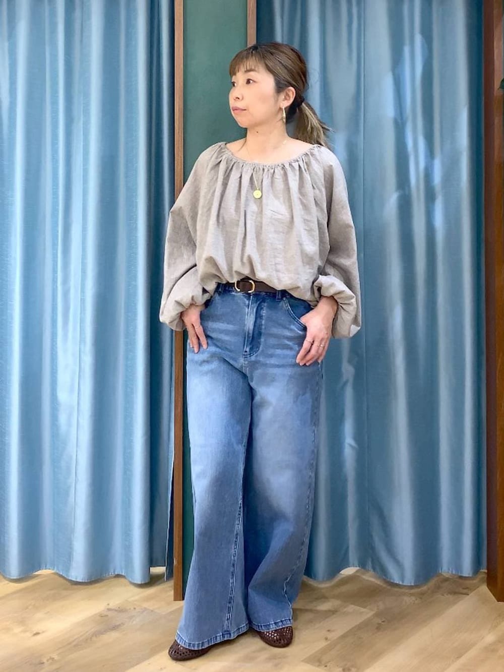 ブルー系のデニムパンツ、ベージュ系のシャツ/ブラウス、ブラウン系のスリッポンを着用したレディースの春コーディネートの2枚目の写真