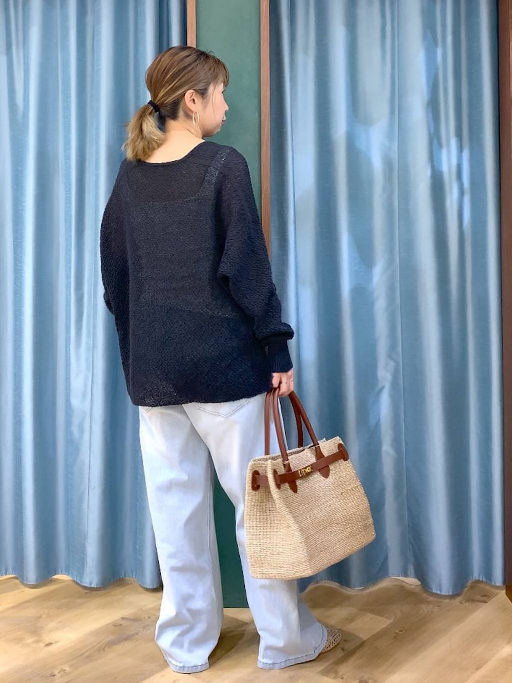 ホワイト系のタンクトップ、ブルー系のデニムパンツ、ブラック系のカーディガン/ボレロを着用したレディースの春コーディネートの5枚目の写真