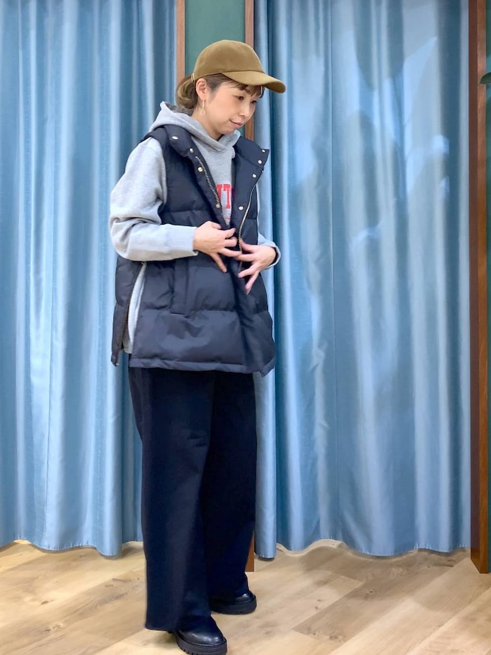 ブラック系のブーツ、グレー系のパーカー、ブラック系のダウンベストを着用したレディースの冬コーディネートの5枚目の写真