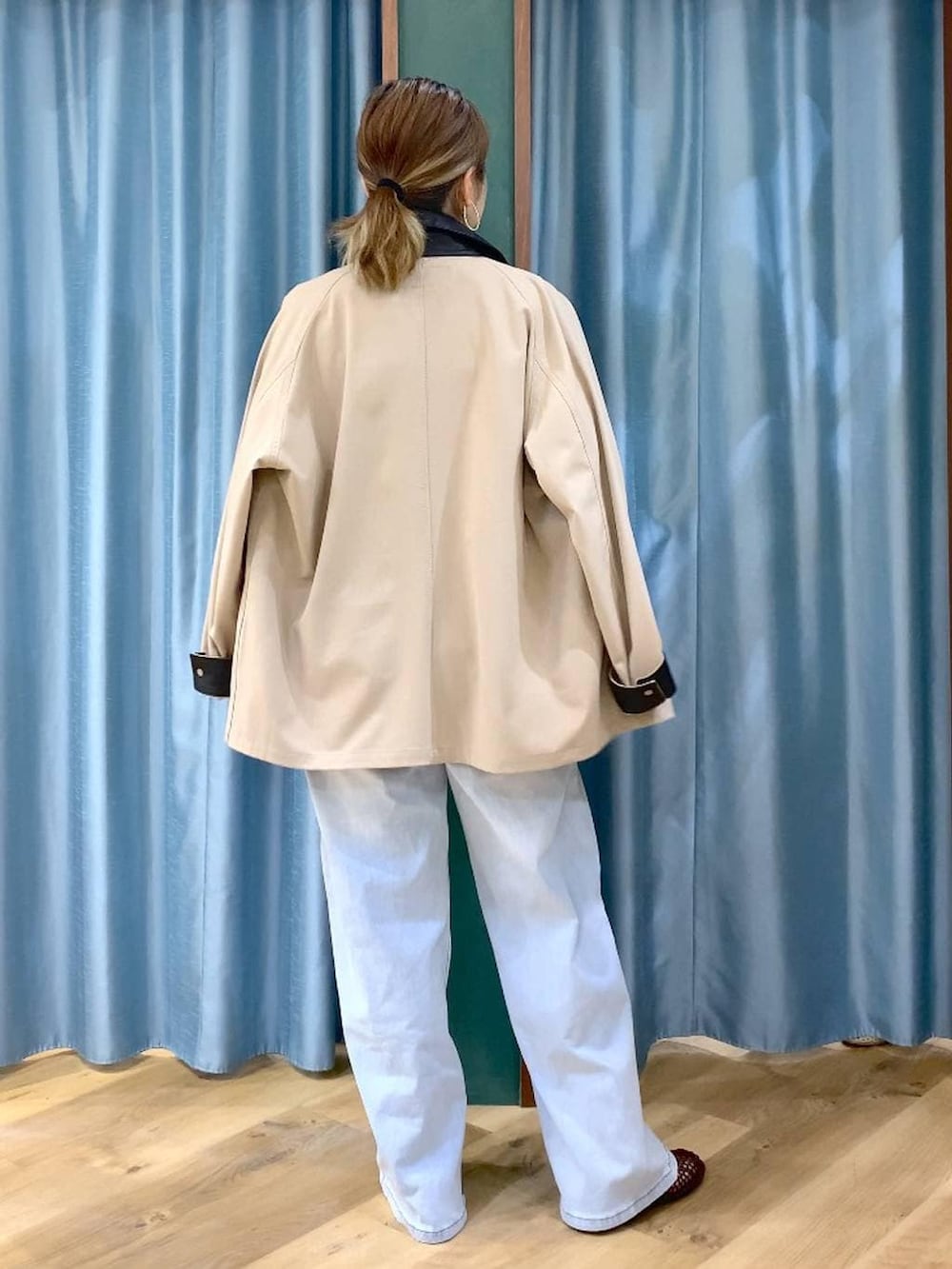 ブルー系のデニムパンツ、ブラウン系のニット/セーター、ベージュ系のカバーオールを着用したレディースの春コーディネートの4枚目の写真