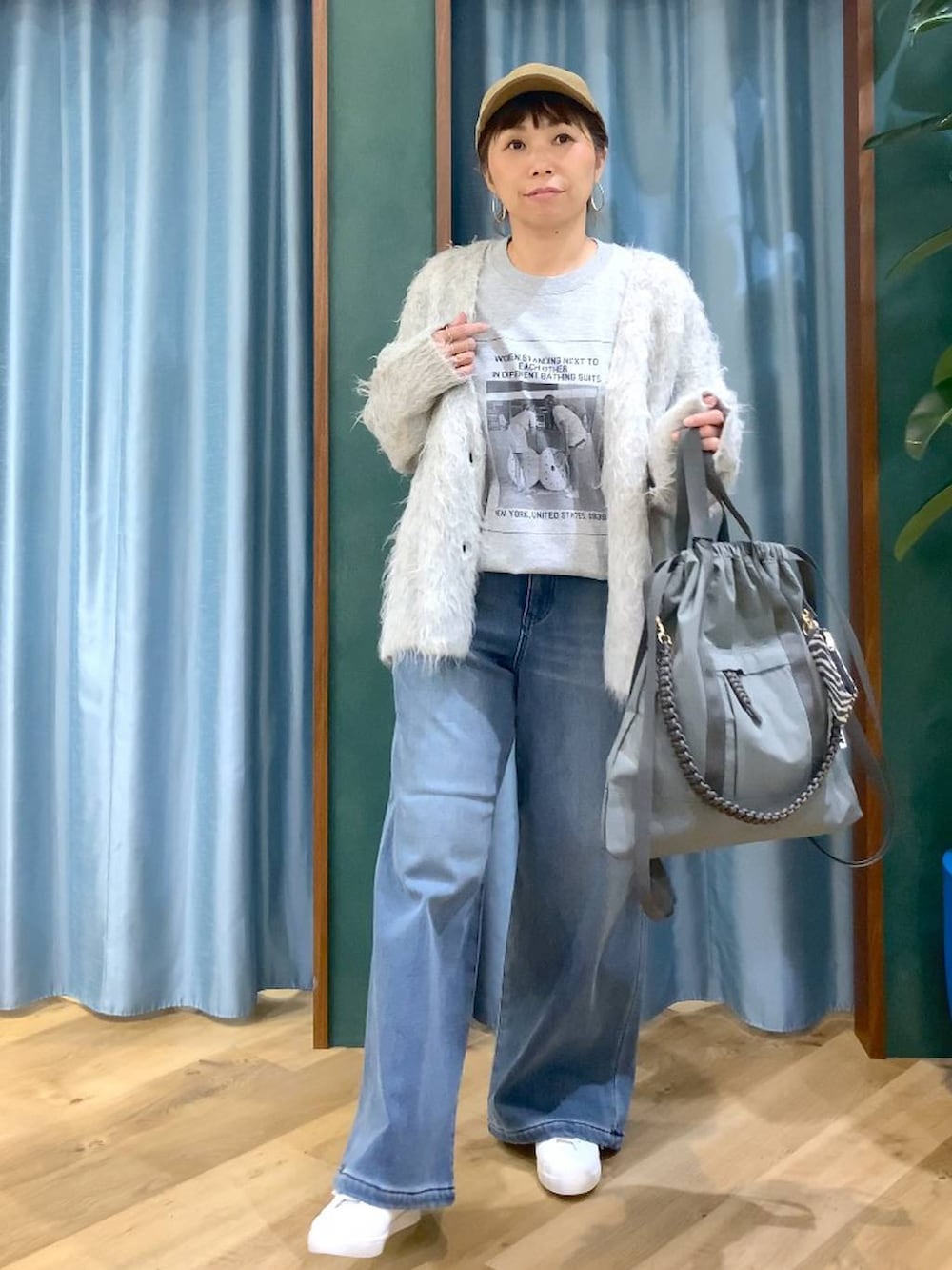 ブルー系のデニムパンツ、グレー系のTシャツ/カットソー、グレー系のバックパック/リュックを着用したレディースの秋コーディネートの8枚目の写真