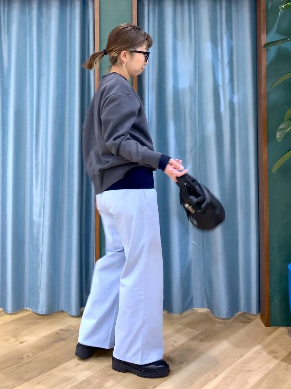 ブラック系のブーツ、ブラック系のショルダーバッグ、ブルー系のニット/セーターを着用したレディースの秋コーディネートの2枚目の写真