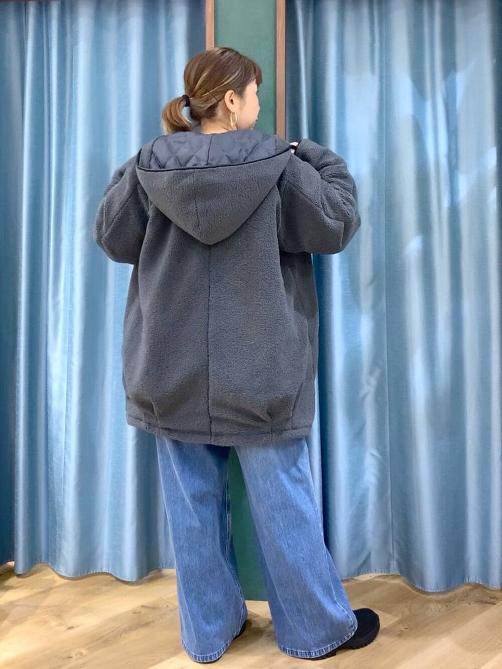 ブラック系のブーツ、ブルー系のデニムパンツ、ブルー系のニット/セーターを着用したレディースの冬コーディネートの3枚目の写真