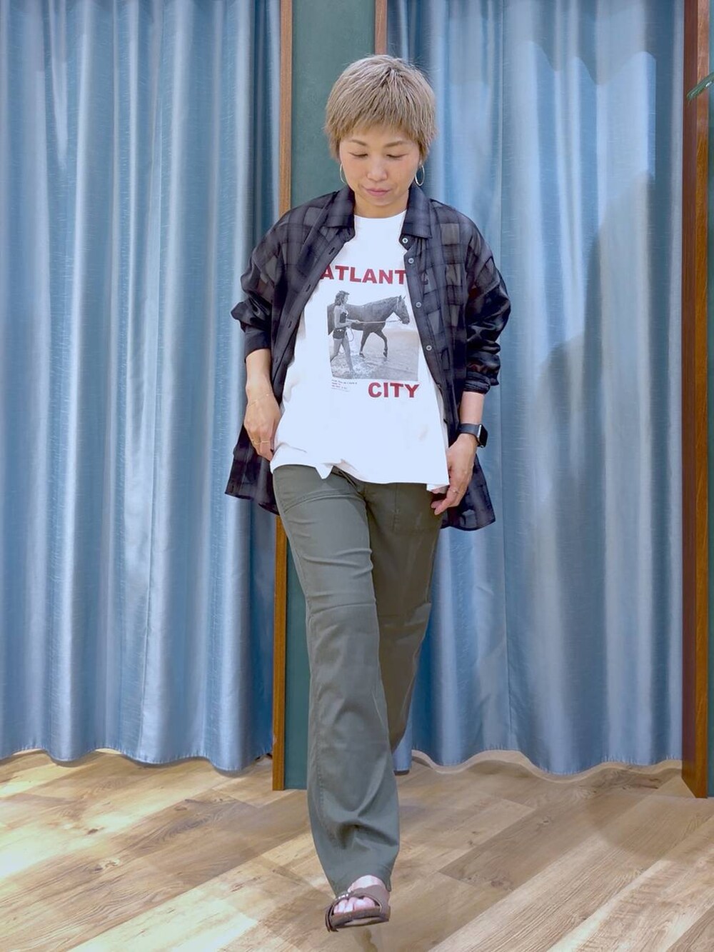 ホワイト系のTシャツ/カットソー、グリーン系のチノパンツ、ブラウン系のサンダルを着用したレディースの夏コーディネートの2枚目の写真