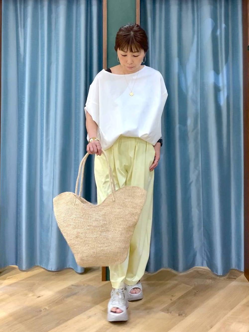 ホワイト系のTシャツ/カットソー、イエロー系のその他パンツ、グレー系のサンダルを着用したレディースの春コーディネートの3枚目の写真