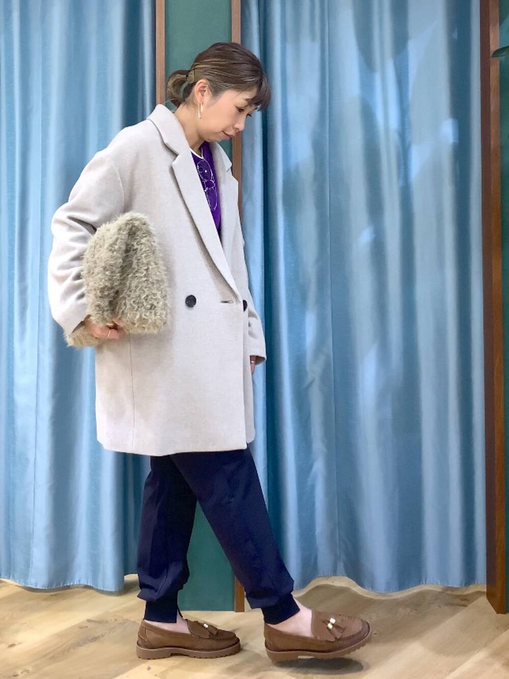 パープル系のニット/セーター、ベージュ系のピーコート、ベージュ系のハンドバッグを着用したレディースの秋コーディネートの2枚目の写真