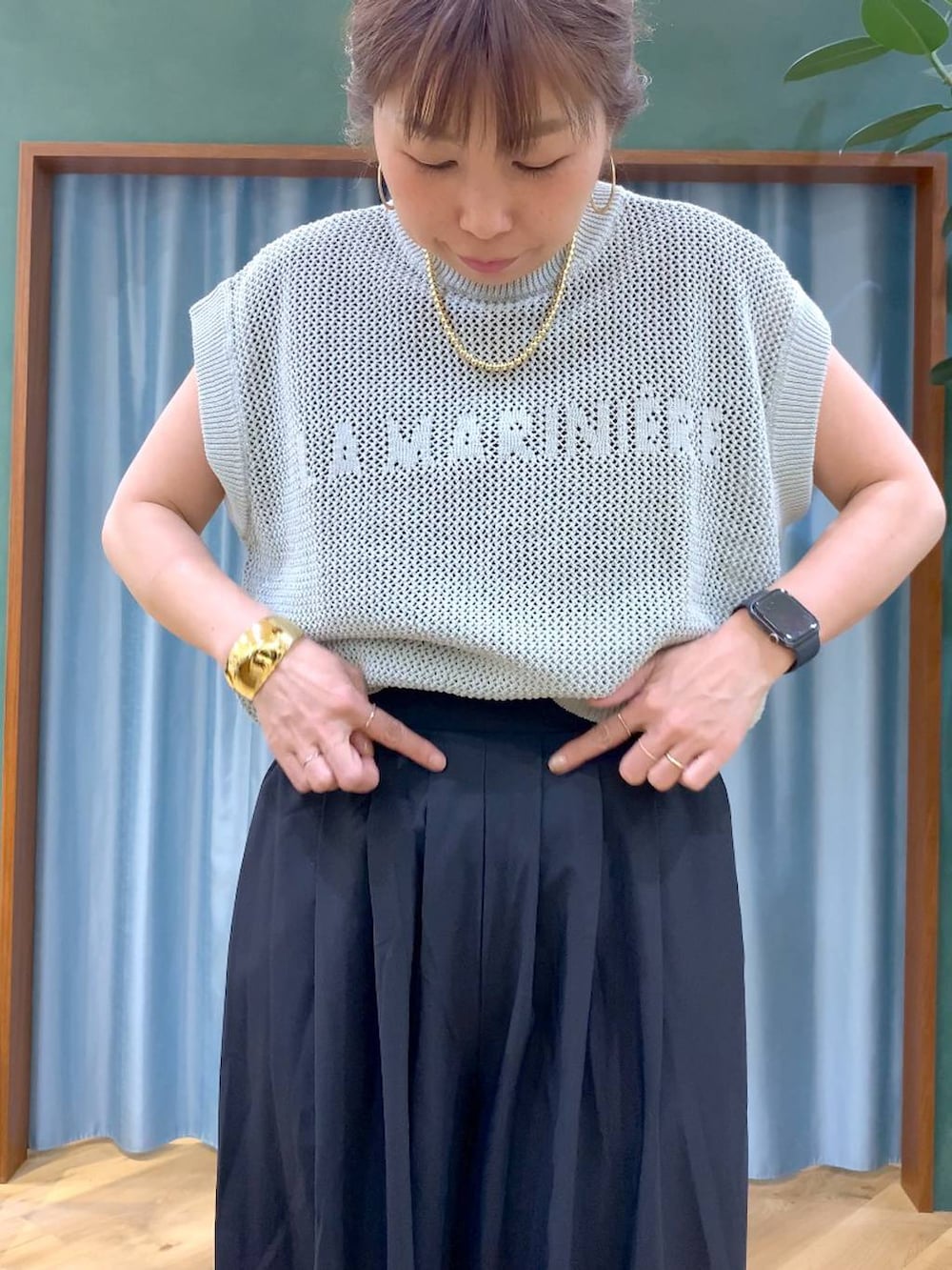 ブラック系のTシャツ/カットソー、グリーン系のニット/セーター、ブラック系のその他パンツを着用したレディースの春コーディネートの9枚目の写真