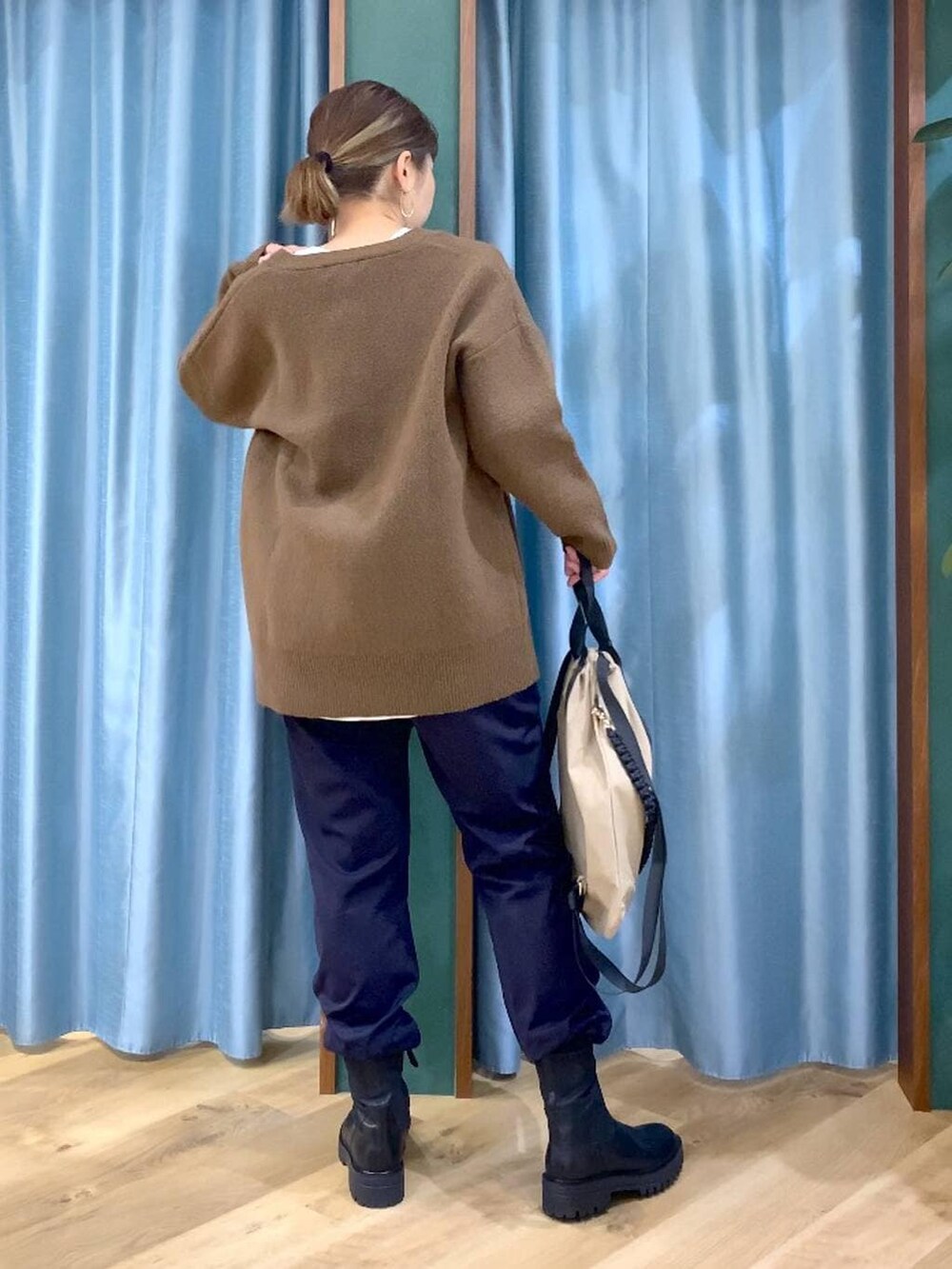 ブラック系のブーツ、ブルー系のその他パンツ、ブラウン系のバックパック/リュックを着用したレディースの冬コーディネートの3枚目の写真