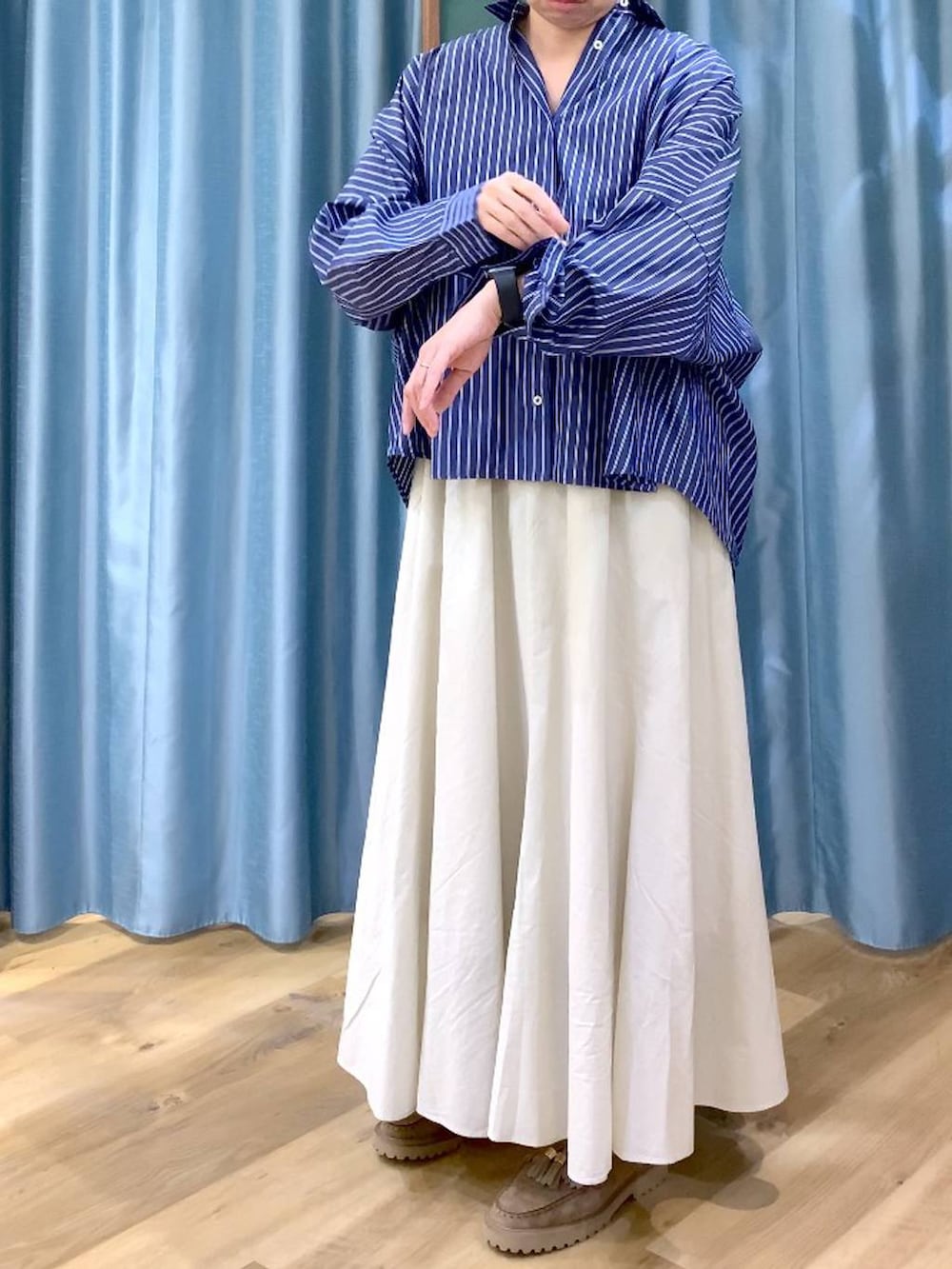 ベージュ系のローファー、ホワイト系のスカート、ブルー系のシャツ/ブラウスを着用したレディースの春コーディネートの9枚目の写真
