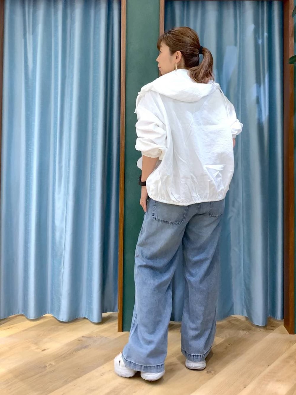 ブルー系のデニムパンツ、ホワイト系のブルゾン、グレー系のサンダルを着用したレディースの春コーディネートの5枚目の写真