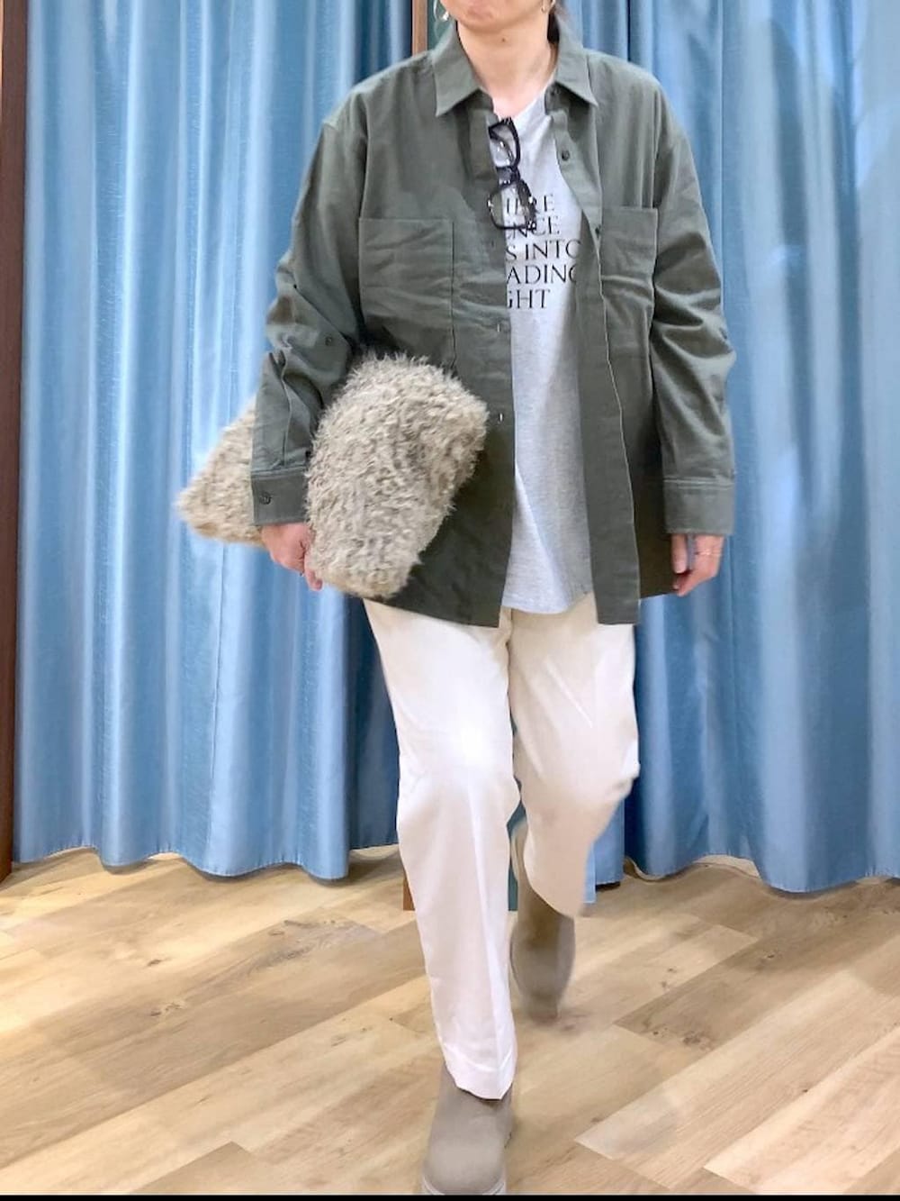 ベージュ系のハンドバッグ、ベージュ系のブーツ、ホワイト系のTシャツ/カットソーを着用したレディースの冬コーディネートの6枚目の写真