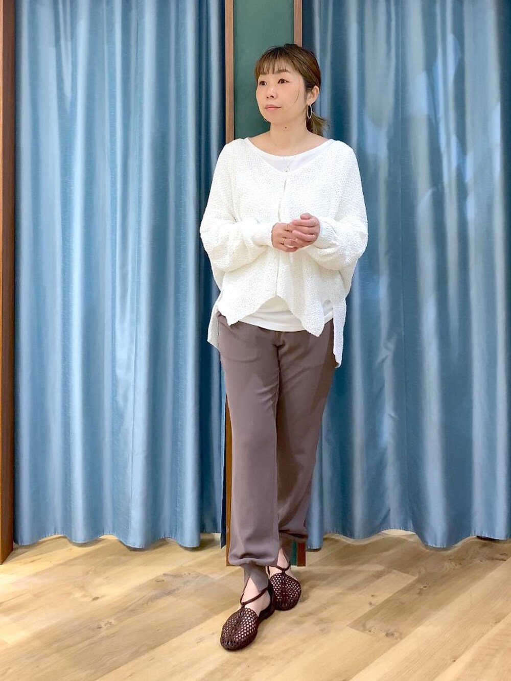 ホワイト系のTシャツ/カットソー、ホワイト系のカーディガン/ボレロ、ブラウン系のスリッポンを着用したレディースの春コーディネートの2枚目の写真