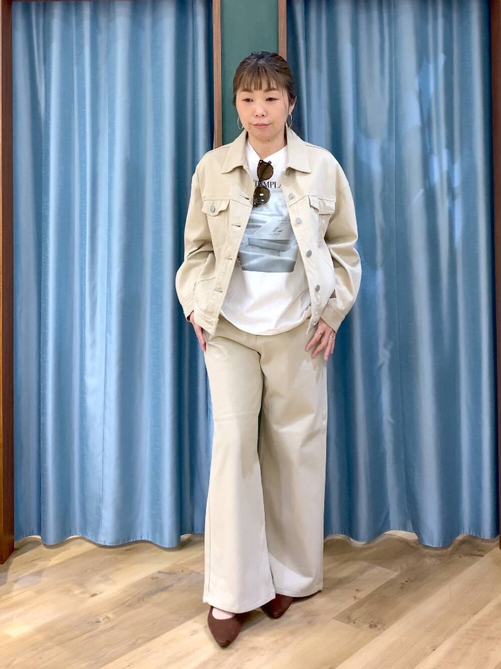 ブラウン系のパンプス、ベージュ系のデニムパンツ、ベージュ系のデニムジャケットを着用したレディースの春コーディネートの2枚目の写真
