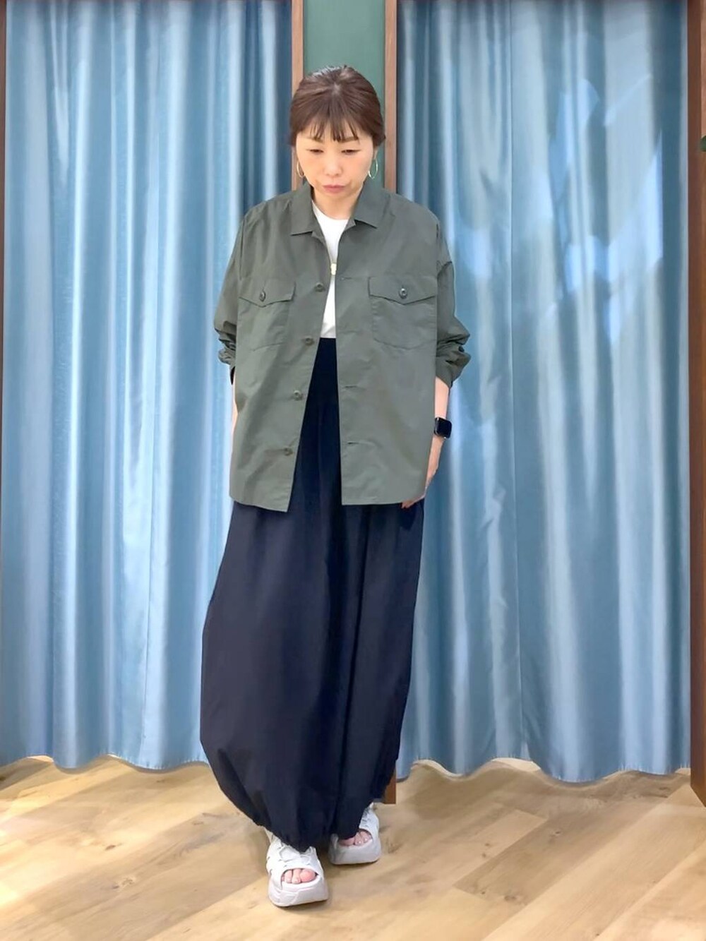 ホワイト系のTシャツ/カットソー、グリーン系のシャツ/ブラウス、グレー系のサンダルを着用したレディースの春コーディネートの2枚目の写真