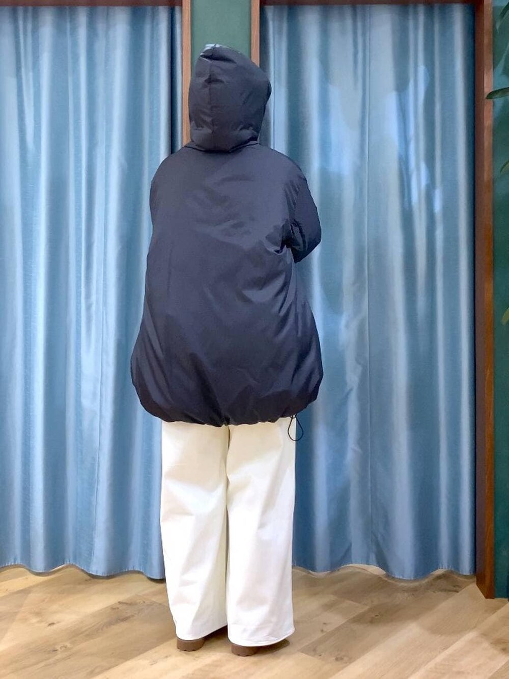 ブルー系のシャツ/ブラウス、ブラック系のダウンジャケット/コート、ブラウン系のローファーを着用したレディースの秋コーディネートの7枚目の写真