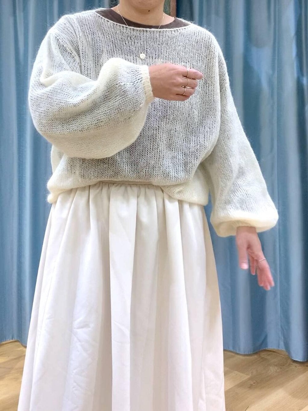 ブラック系のブーツ、ホワイト系のスカート、ホワイト系のニット/セーターを着用したレディースの冬コーディネートの7枚目の写真