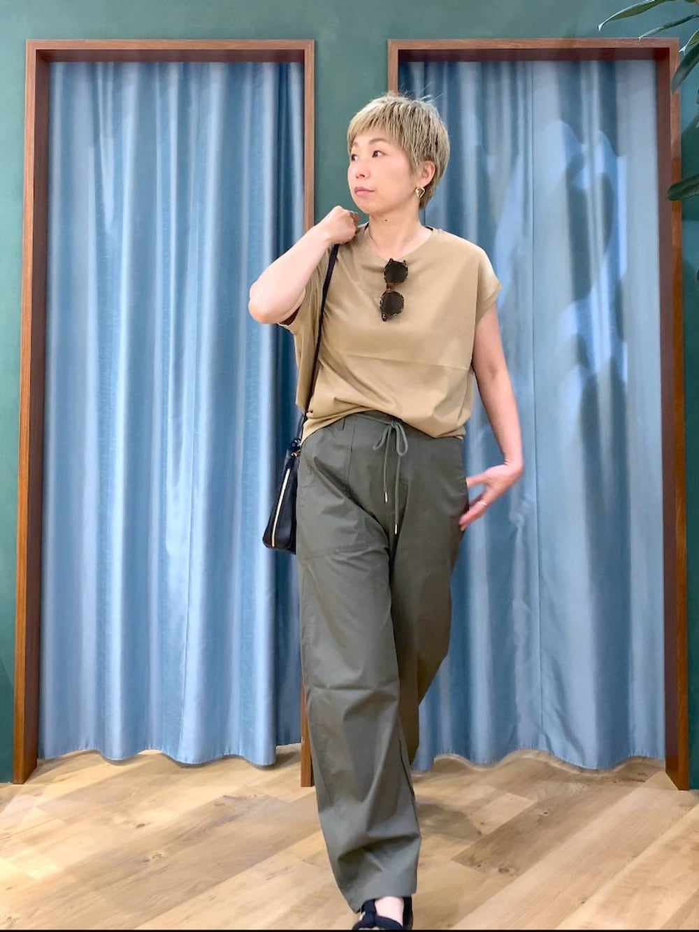 ブラック系のショルダーバッグ、グリーン系のカーゴパンツ、ブラック系のサンダルを着用したレディースの夏コーディネートの7枚目の写真