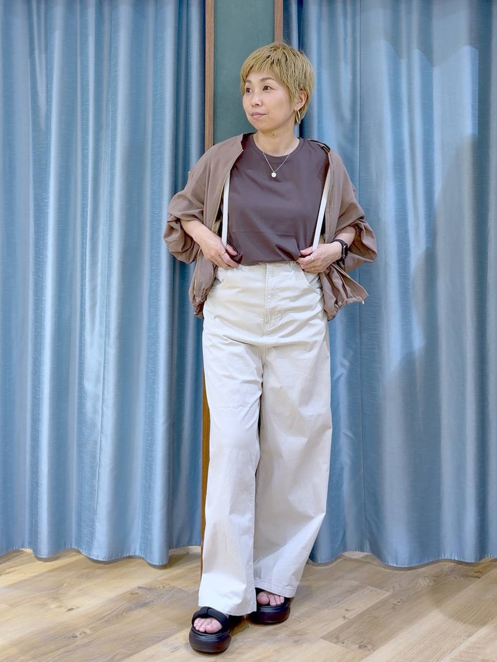 イエロー系のブルゾン、ベージュ系のその他パンツ、ブラック系のサンダルを着用したレディースの夏コーディネートの2枚目の写真