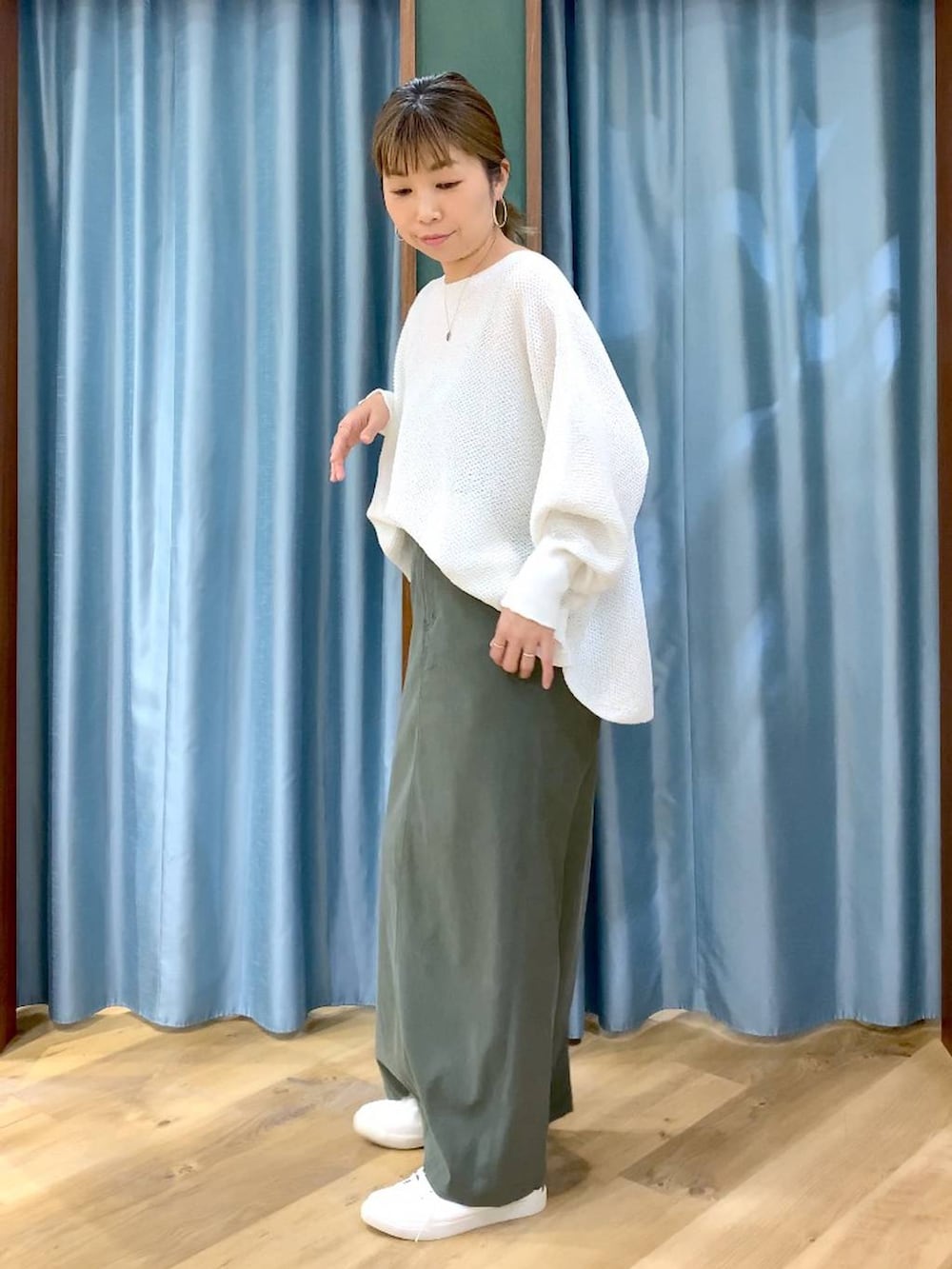 ホワイト系のニット/セーター、グリーン系のスカート、ブラウン系のスニーカーを着用したレディースの春コーディネートの4枚目の写真