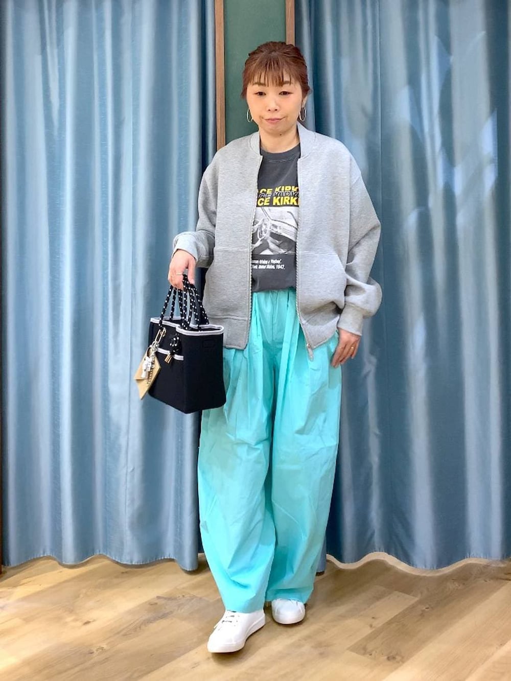 グリーン系のその他パンツ、グレー系のブルゾン、ブラウン系のスニーカーを着用したレディースの春コーディネートの3枚目の写真