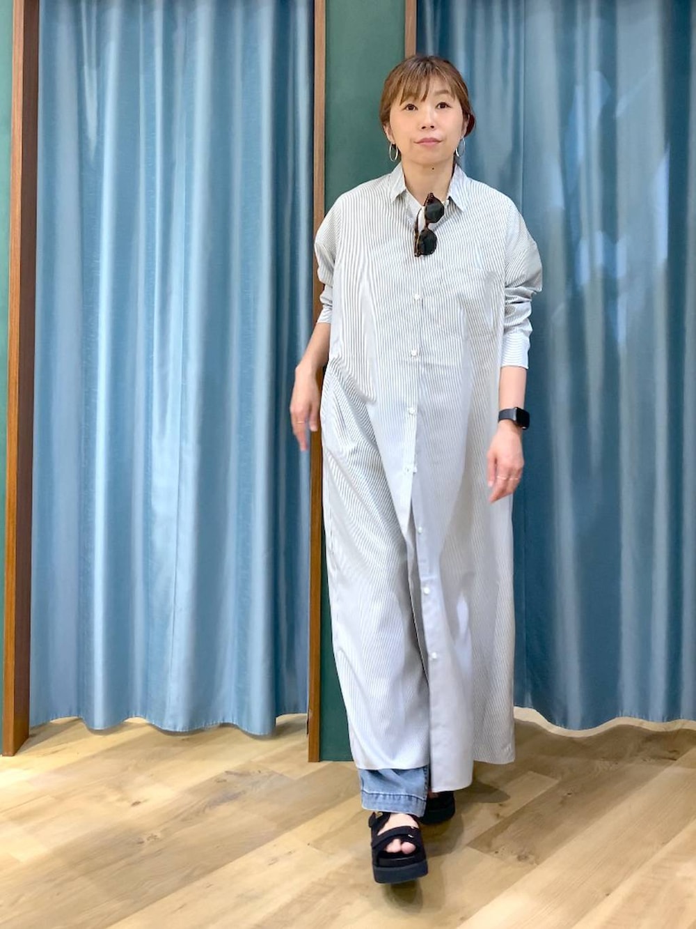 ブラック系のワンピース、ブルー系のデニムパンツ、ブラック系のサンダルを着用したレディースの春コーディネートの3枚目の写真