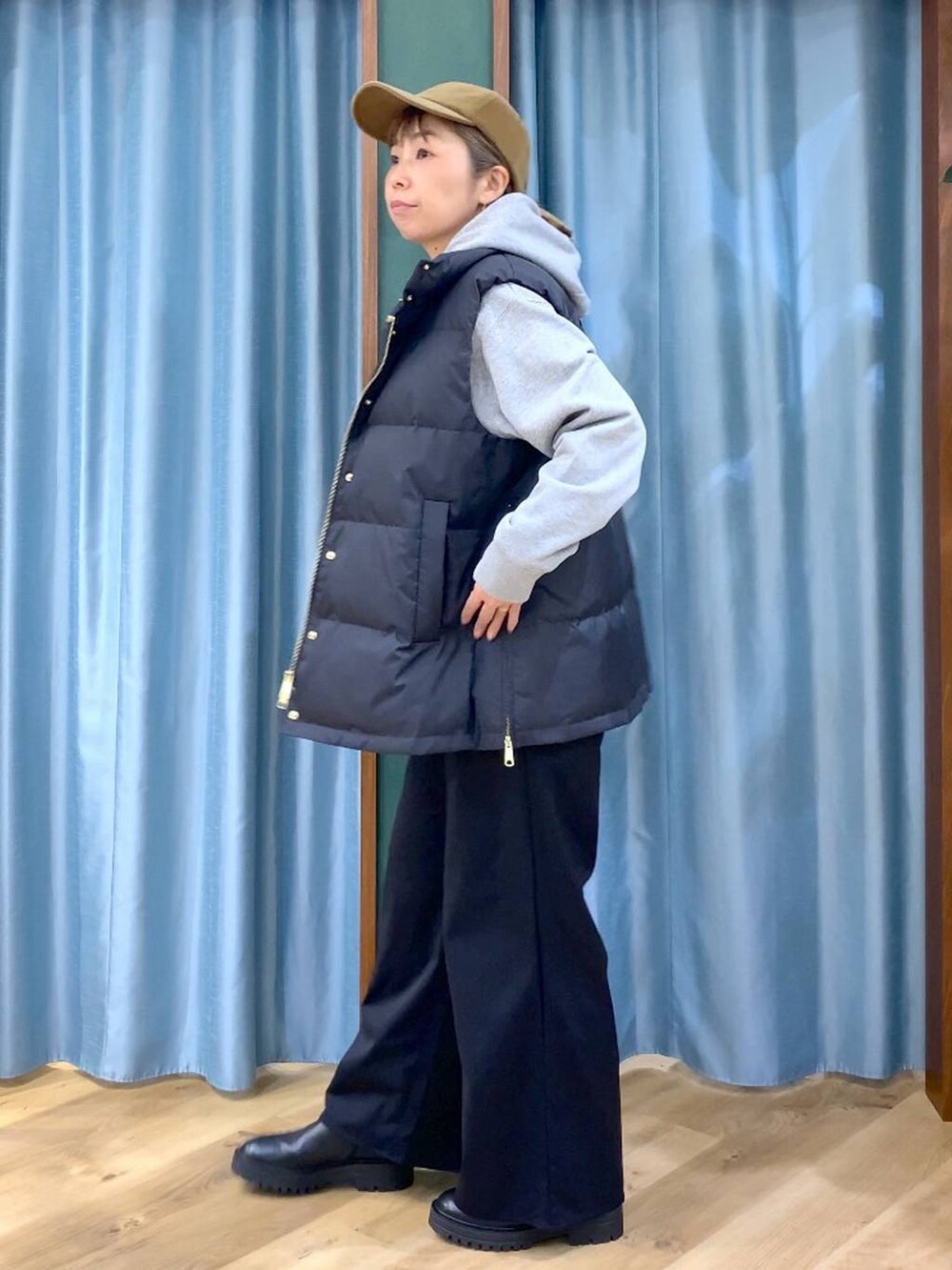 ブラック系のブーツ、グレー系のパーカー、ブラック系のダウンベストを着用したレディースの冬コーディネートの4枚目の写真