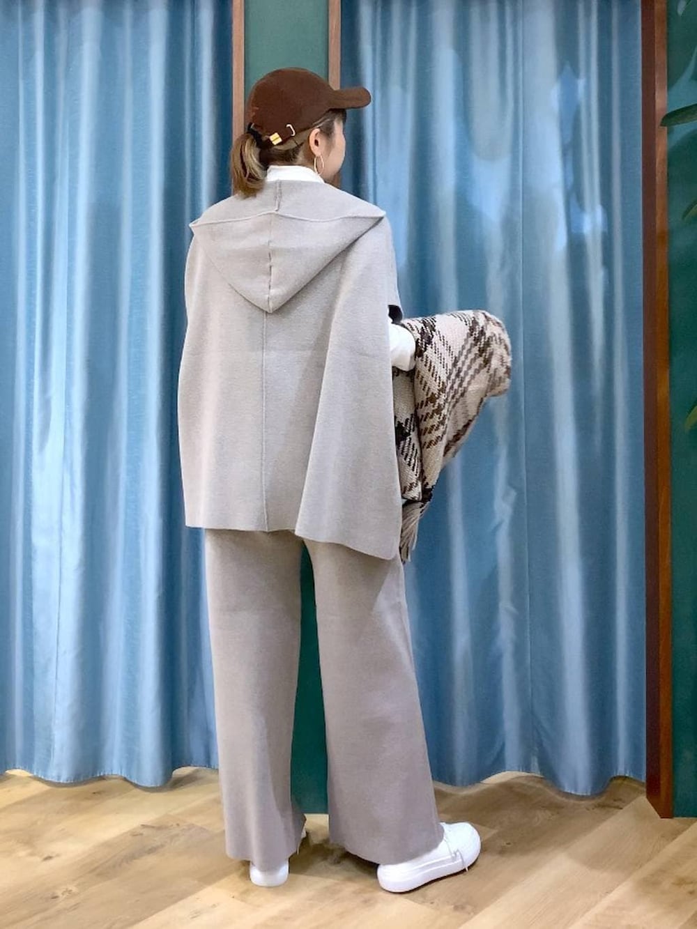 グレー系のベスト、グレー系のその他パンツ、ホワイト系のスニーカーを着用したレディースの冬コーディネートの5枚目の写真