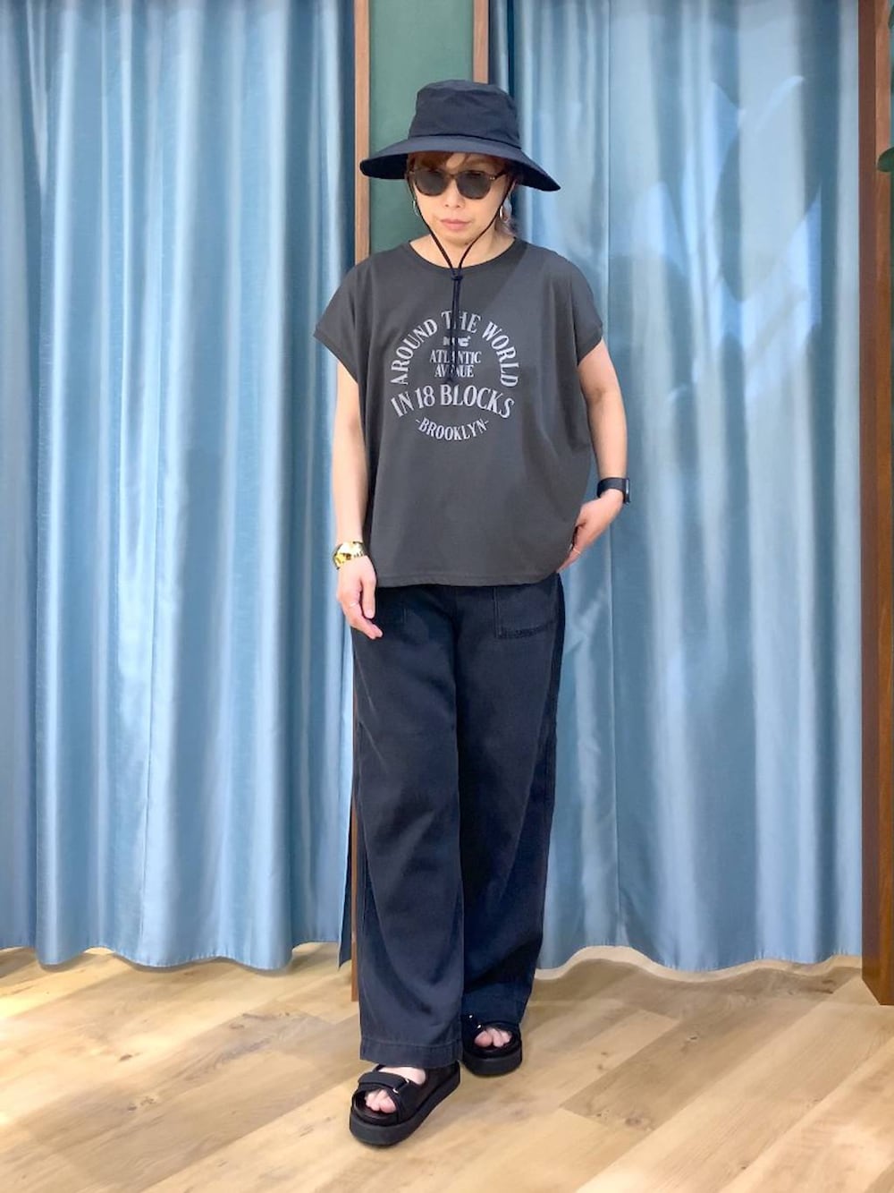 ブラック系のTシャツ/カットソー、グレー系のデニムパンツ、ブラック系のサンダルを着用したレディースの春コーディネートの4枚目の写真