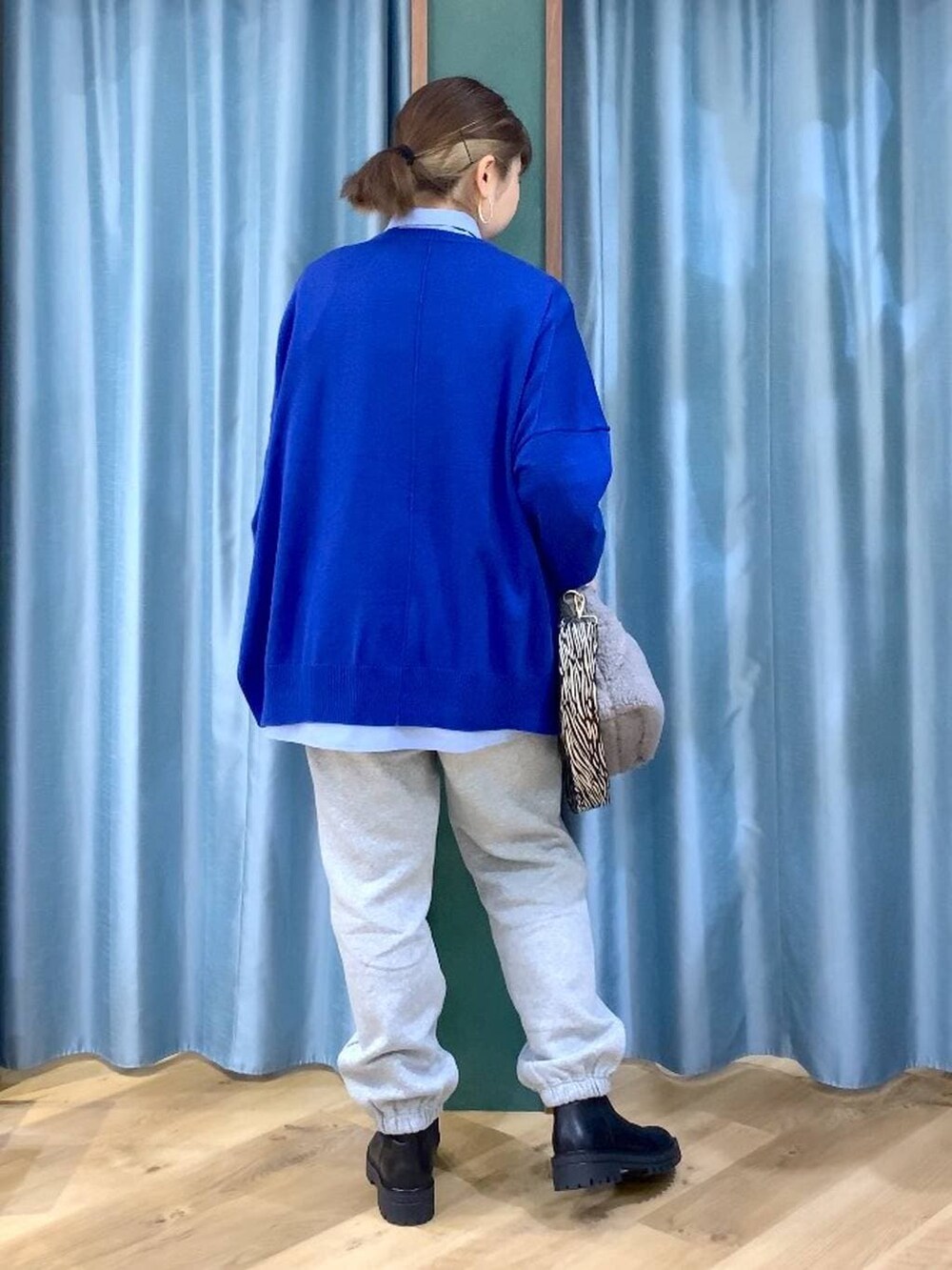 ブラック系のブーツ、ブルー系のシャツ/ブラウス、グレー系のトートバッグを着用したレディースの秋コーディネートの4枚目の写真