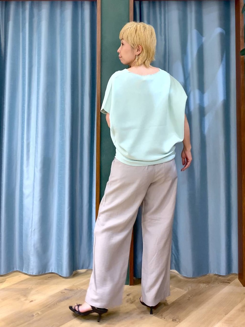 グリーン系のニット/セーター、ベージュ系のその他パンツ、ブラック系のサンダルを着用したレディースの春コーディネートの4枚目の写真
