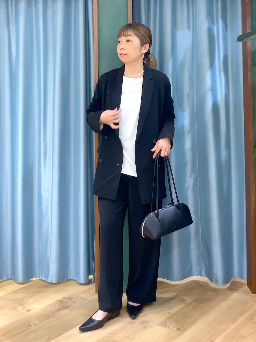 ブラック系のスラックス、ホワイト系のTシャツ/カットソー、ブラック系のテーラードジャケットを着用したレディースの冬コーディネートの3枚目の写真