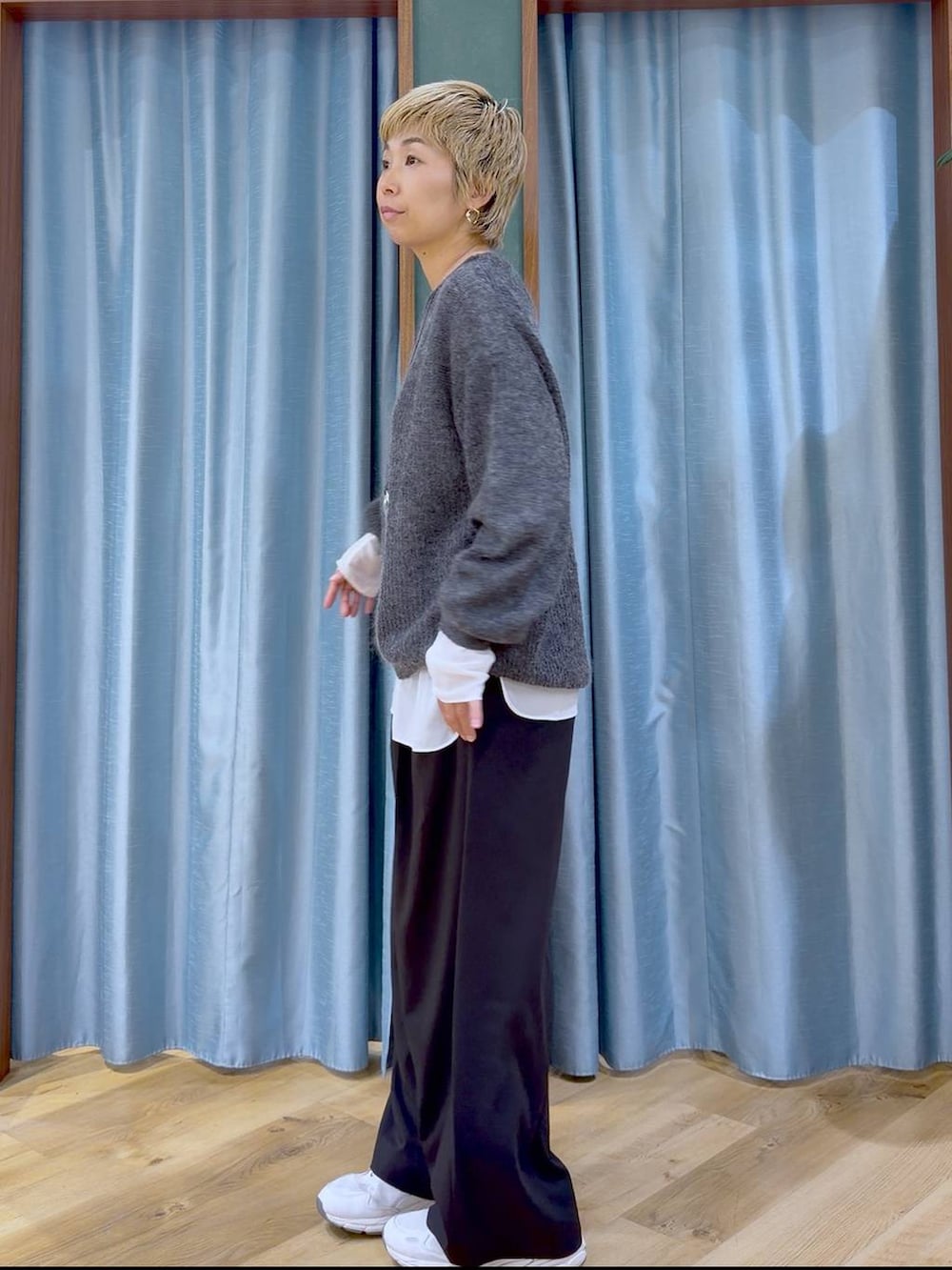 グレー系のニット/セーター、ブラック系のその他パンツ、ホワイト系のTシャツ/カットソーを着用したレディースの秋コーディネートの5枚目の写真