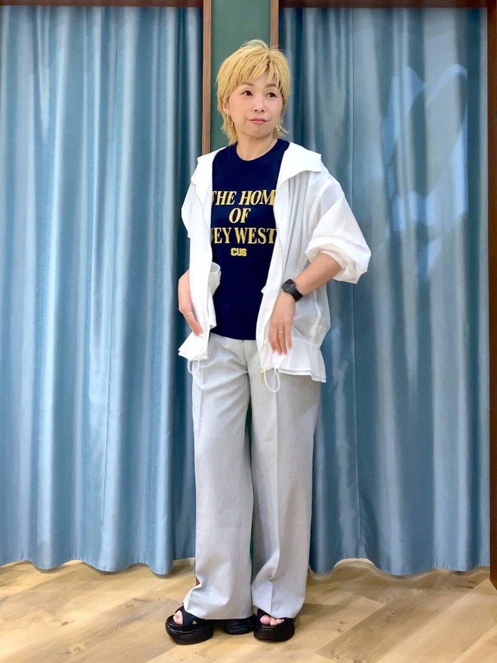 ブルー系のTシャツ/カットソー、ブラック系のサンダル、ホワイト系のブルゾンを着用したレディースの夏コーディネートの3枚目の写真