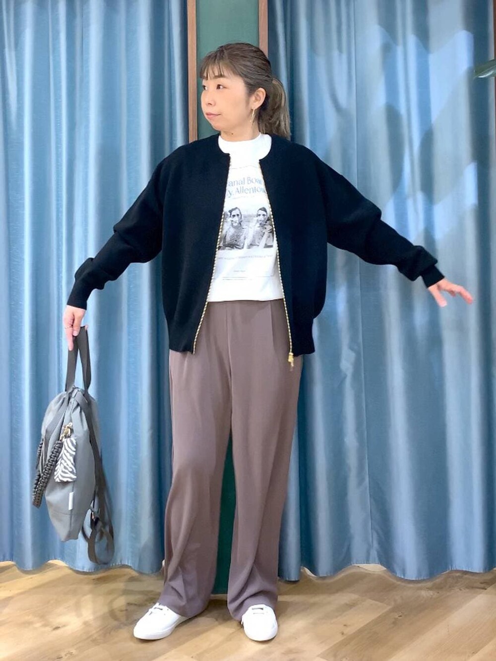 グリーン系のスラックス、ブラック系のカーディガン/ボレロ、グレー系のバックパック/リュックを着用したレディースの冬コーディネートの7枚目の写真