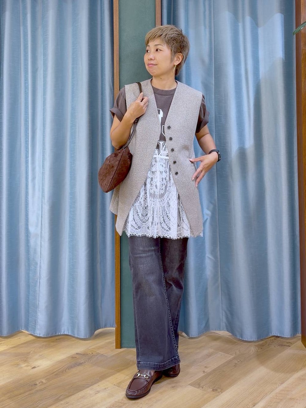 ブラウン系のショルダーバッグ、ブラウン系のローファー、グレー系のTシャツ/カットソーを着用したレディースの夏コーディネートの4枚目の写真