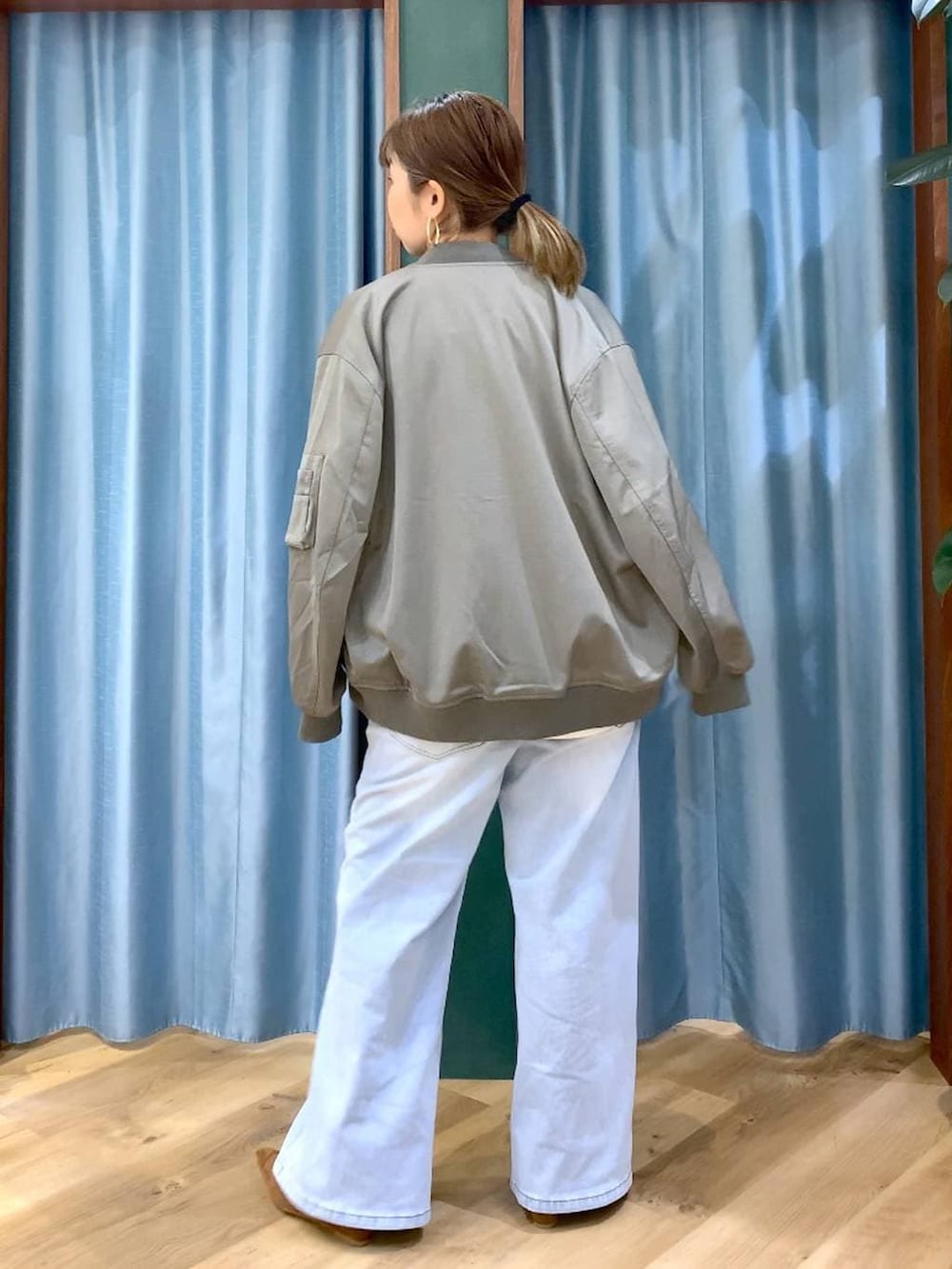 ブルー系のデニムパンツ、ホワイト系のTシャツ/カットソー、グリーン系のMA-1を着用したレディースの冬コーディネートの7枚目の写真