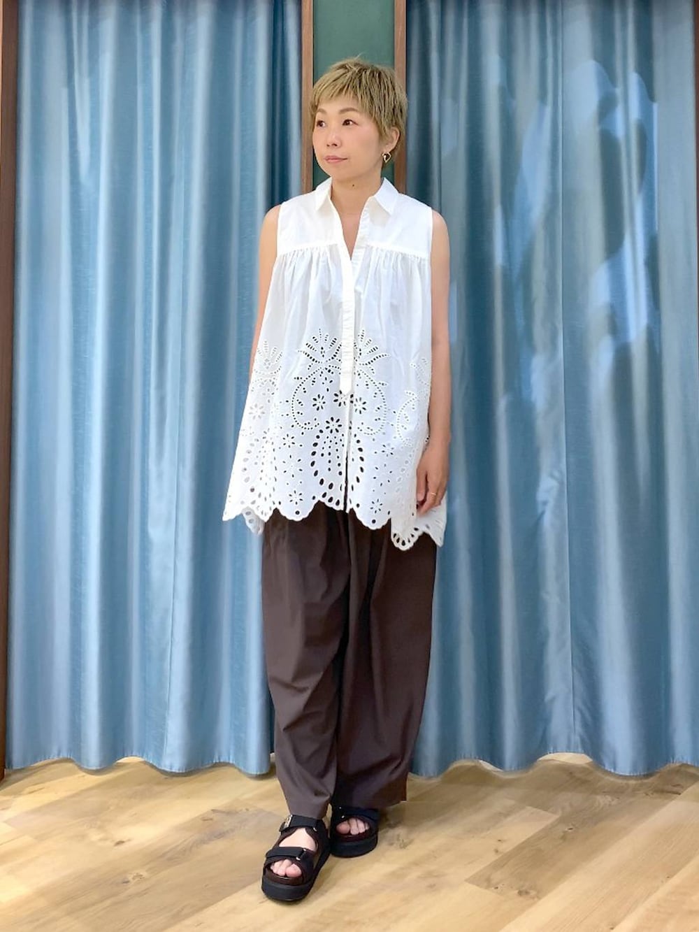 ブラウン系のその他パンツ、ホワイト系のシャツ/ブラウス、ブラウン系のサンダルを着用したレディースの夏コーディネートの2枚目の写真