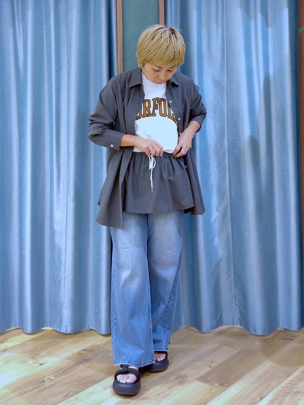 ブラック系のサンダル、グレー系のシャツ/ブラウス、ホワイト系のTシャツ/カットソーを着用したレディースの夏コーディネートの2枚目の写真